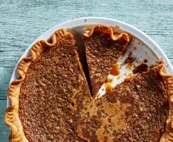 Une tarte au sucre avec deux pointes coupées, dont une manquante, dans un moule à tarte blanc